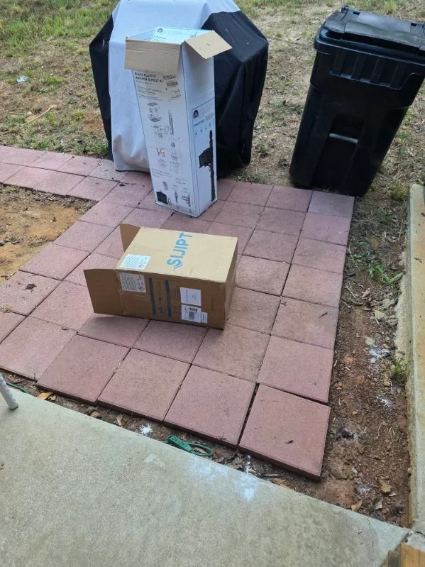 Clay brick pavers staged on prepared base with landscape edging and soil grading