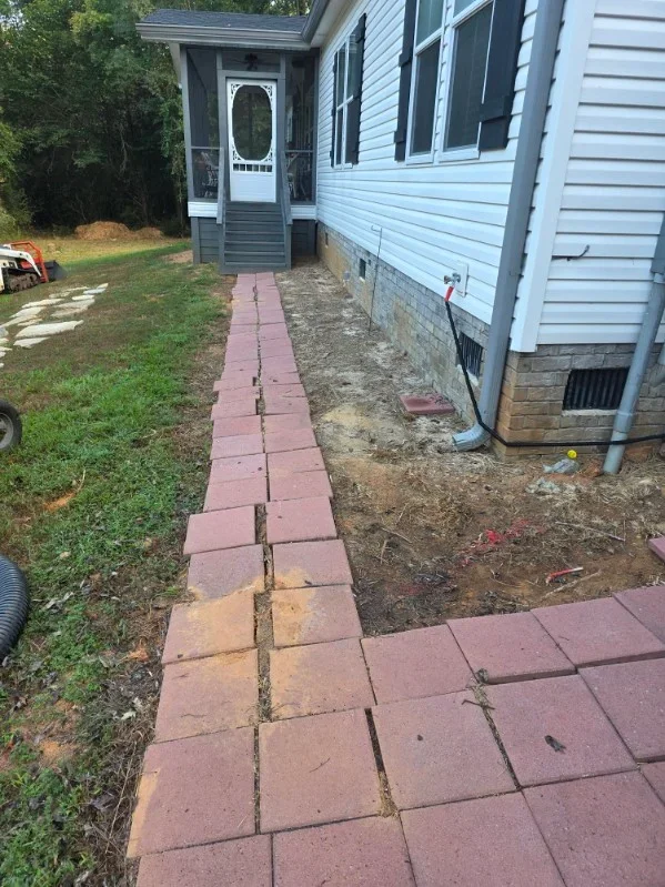 Red clay paver walkway installation with proper base preparation and grading